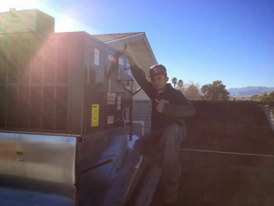 HVAC technician performing Heat Pump Repair on a rooftop unit in Brentwood